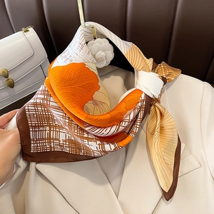 Elegant orange floral silk scarf with brown grid pattern on white blazer collar