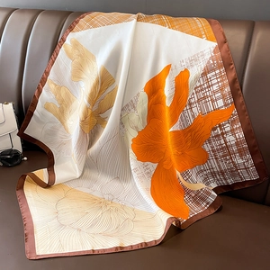 Elegant floral silk scarf with orchid print and checkered pattern on leather background