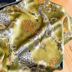 Détail d'un foulard en soie de luxe avec motifs floraux vintage et bords roulottés