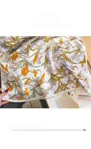 Detailed close-up showing the fine edge stitching on the floral silk square scarf