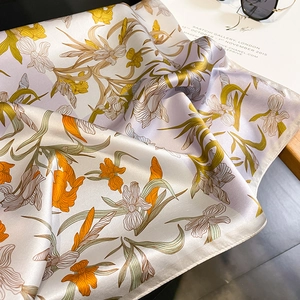 Detail of silk scarf featuring iris floral patterns and hand-rolled edges on display