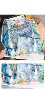 Détail de l'imprimé feuilles tropicales et des coutures fines sur foulard en soie