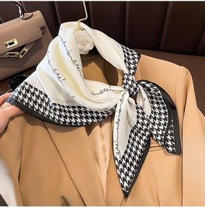 Detail eines Seidengefühl-Halstuchs mit Hahnentritt-Muster auf einem beigen Blazer