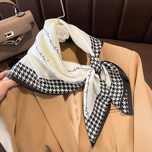 Eleganter Seidenschal mit Hahnentrittmuster und Who is Me Aufdruck auf einem Blazer