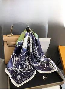 Detailed view of a silk square scarf with vintage carriage patterns tied to a leather handbag