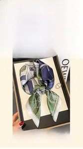 Close-up of a 70x70cm mulberry silk scarf with geometric patterns in blue and olive green