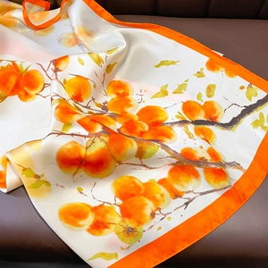 Elegant silk scarf with orange persimmon print and bright orange borders on leather back