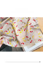 Detailed view of the fine machine-stitched edge on a silk scarf with paisley patterns