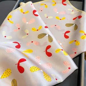 Close-up of printed silk square scarf with floral pattern and pearlescent texture