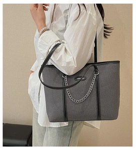 Dettaglio della borsa tote in denim grigio con catena argento e manici in ecopelle nera