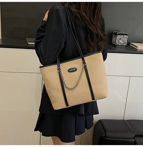 Dettaglio della borsa tote in tela kaki con finiture in pelle nera e catena argento
