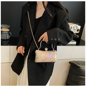 Detalle de bolso de noche de lentejuelas oro champán con patrones de plumas de colores