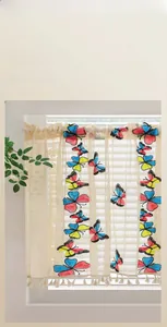 Detailed embroidery of colorful butterflies on cream lace curtain with tassels