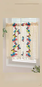 Detail of colorful butterfly embroidery and beige tassels on short lace cafe curtains