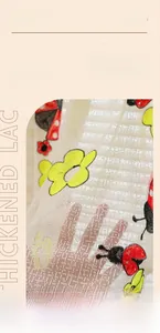 Macro detail of thickened lace fabric with floral embroidery and ladybug patterns