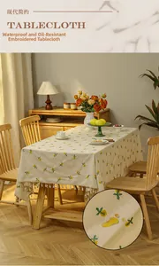 Close-up of waterproof and oil-proof beige tablecloth with yellow floral embroidery