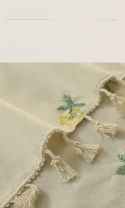 Close-up of floral embroidery and fringe details on beige linen waterproof tablecloth