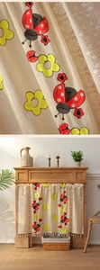 Detailed close-up of lace cafe curtain with ladybug embroidery and white tassels