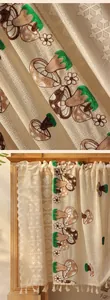 Detail of embroidered mushroom and daisy pattern on beige lace cafe curtain with tassels