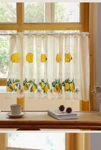 Close-up of lemon embroidery on cream mesh cafe curtain with wavy scalloped lace edge