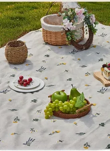 Detailed texture of floral picnic mat with yellow flowers and lavender on green grass