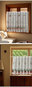 Close-up of white lace cafe curtain featuring red strawberry embroidery and scalloped edges