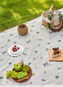 Close-up of the floral picnic mat featuring lavender and yellow flowers on cream fabric