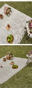 Detail of outdoor picnic mat with floral tulip pattern and elegant scalloped lace edges