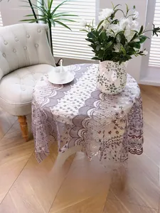Détail de nappe en dentelle vintage française avec broderie florale et bordure festonnée