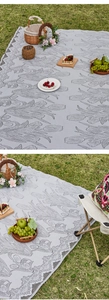 Detail of tulip pattern jacquard picnic mat with elegant scalloped lace edges on grass