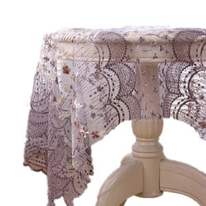 Nappe en dentelle brodée avec motifs floraux vintage et bords festonnés élégants