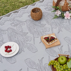 Outdoor lace picnic mat featuring tulip pattern and elegant lace border on grass