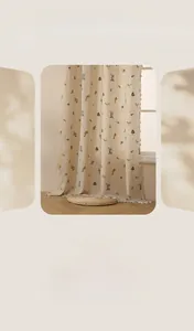 Détail de broderie de blé sur rideaux en lin beige semi-transparents avec pompons