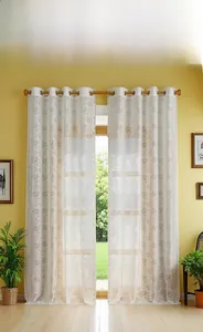 Detail of white lace curtain with embroidered flower patterns and silver eyelets