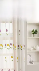 Detailed close-up of high-quality tulip embroidery on semi-transparent white window sheer