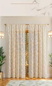 Close-up of cream tulip lace curtain with scalloped edges and floral embroidery