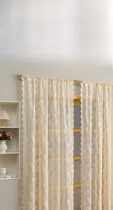 Detail of cream lace curtain featuring intricate tulip floral embroidery and wavy edges