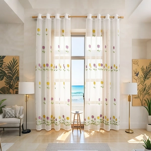 White semi-transparent tulip embroidered curtains with eyelet rings in a sunny living room