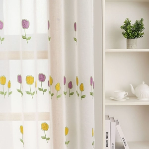 White sheer curtain with tulip embroidery in a bright, minimalist modern living room