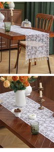 Detailed white lace table runner with butterfly patterns and elegant fringe trim