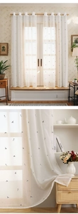 Detailed macro view of white sheer curtain fabric with small cat embroidery patterns