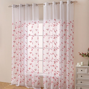 White sheer curtains with red vine embroidery and metal grommets in a bright living room