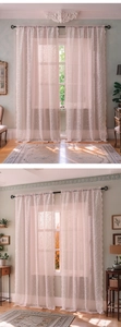 Close-up of pink lace curtains featuring floral embroidery and scalloped edges