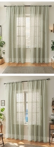 Detail of light green floral lace sheer curtains with scalloped edges and rod pocket design