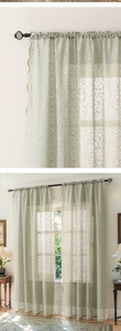 Detailed view of sage green lace curtains with floral embroidery and scalloped edges