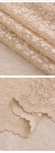Close-up of floral hollow lace sheer curtain with delicate scalloped edge in cream beige