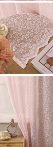 Detail of pink floral lace curtain featuring delicate hollow patterns and scalloped edges