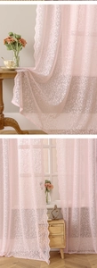 Detail of pink floral lace curtain with delicate embroidery and scalloped edges