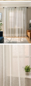 Close-up of white floral lace curtain with elegant scalloped edges and delicate embroidery