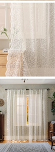 Detail of white floral lace curtains with intricate embroidery and elegant scalloped edges